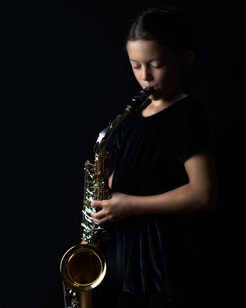 fine art portrait of a 8 year old girl traditional black dress with saxophone ideas for posing in Farmington CT
