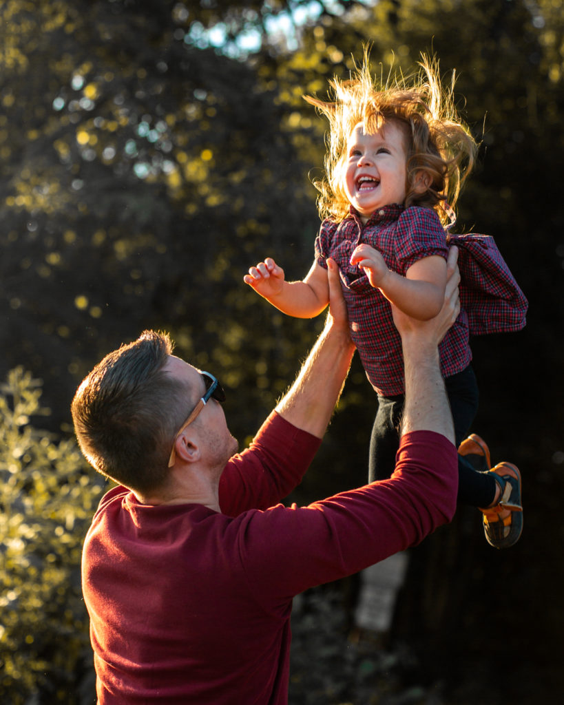 father playing with daughter in a family photoshoot