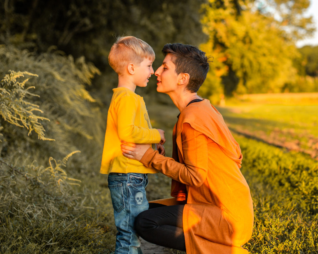 mother and son posing kissing young boy with mother rusty Christmas shoot