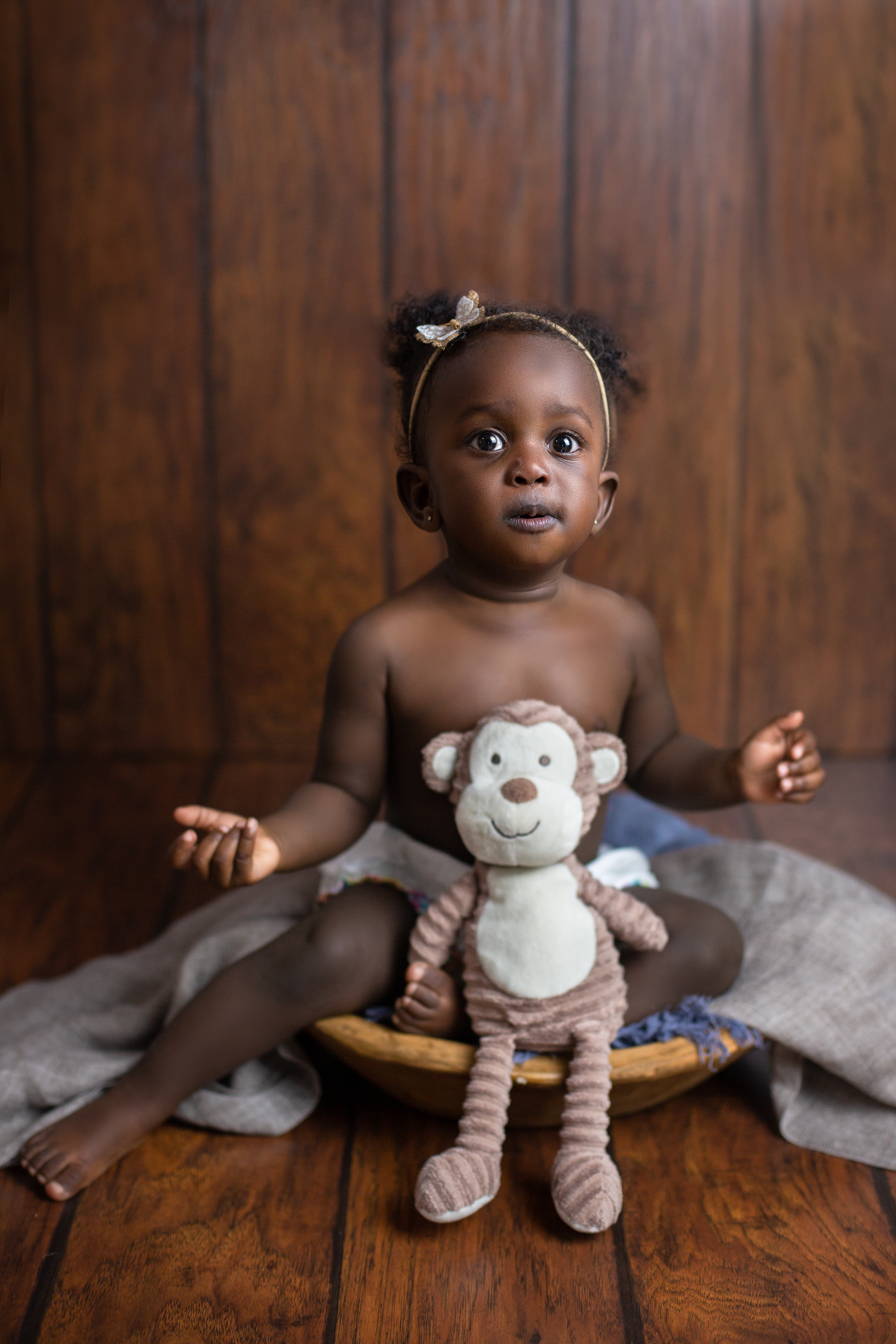 cake smash black African American baby girl in white farmington ct brown wooden backdrop with stuffed toy