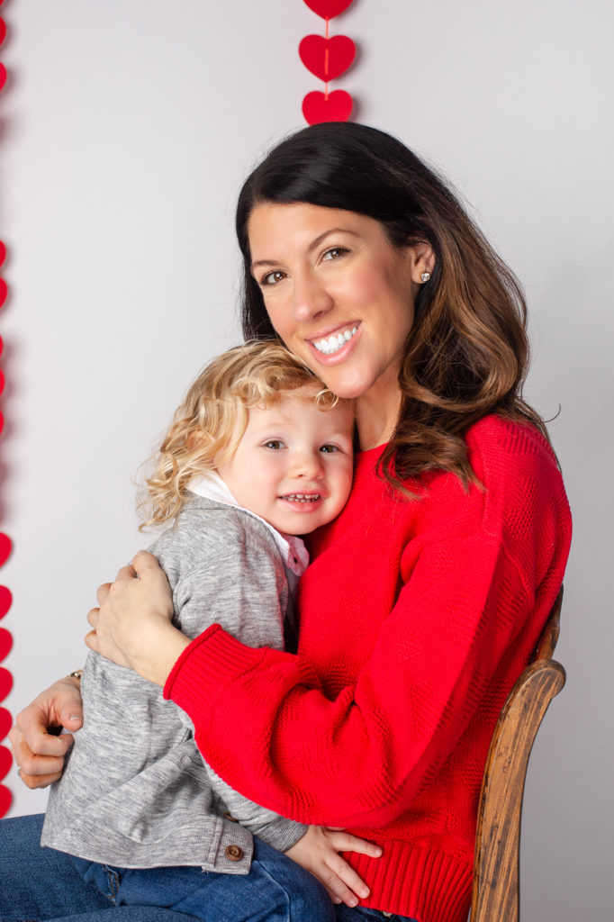 mother holding her toddler son for cvalentines session hearts red