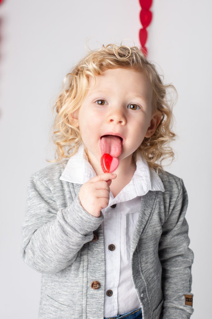 child licking lolly pop heart shaped for a mini session