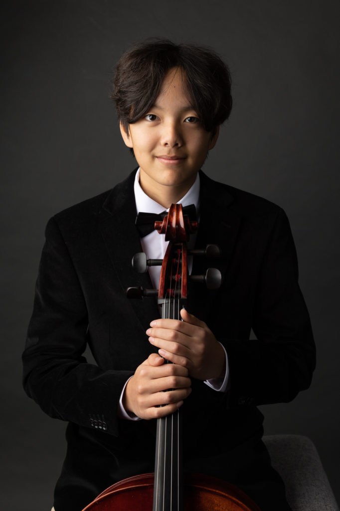 boy musician player portrait with cello dark background