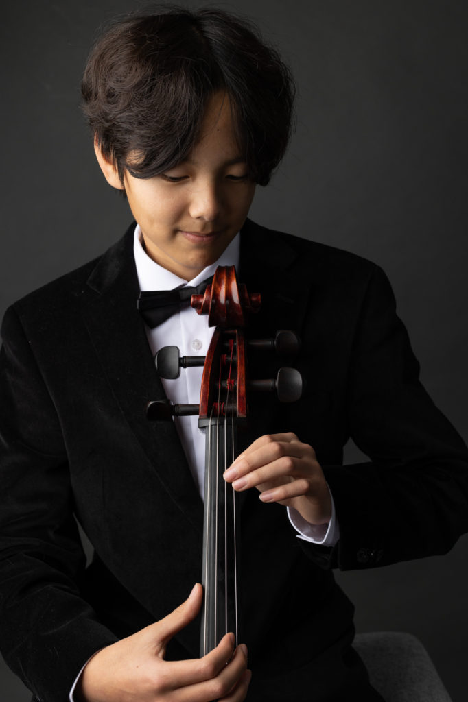 boy musician player portrait with cello dark background