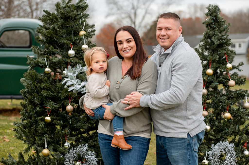 Christmas mini session family green truck and Christmas trees with a baby
