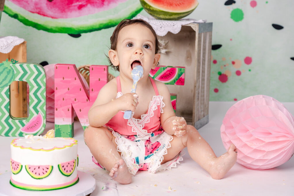 baby cake smash watermelon eating cake girl in pink and green romper