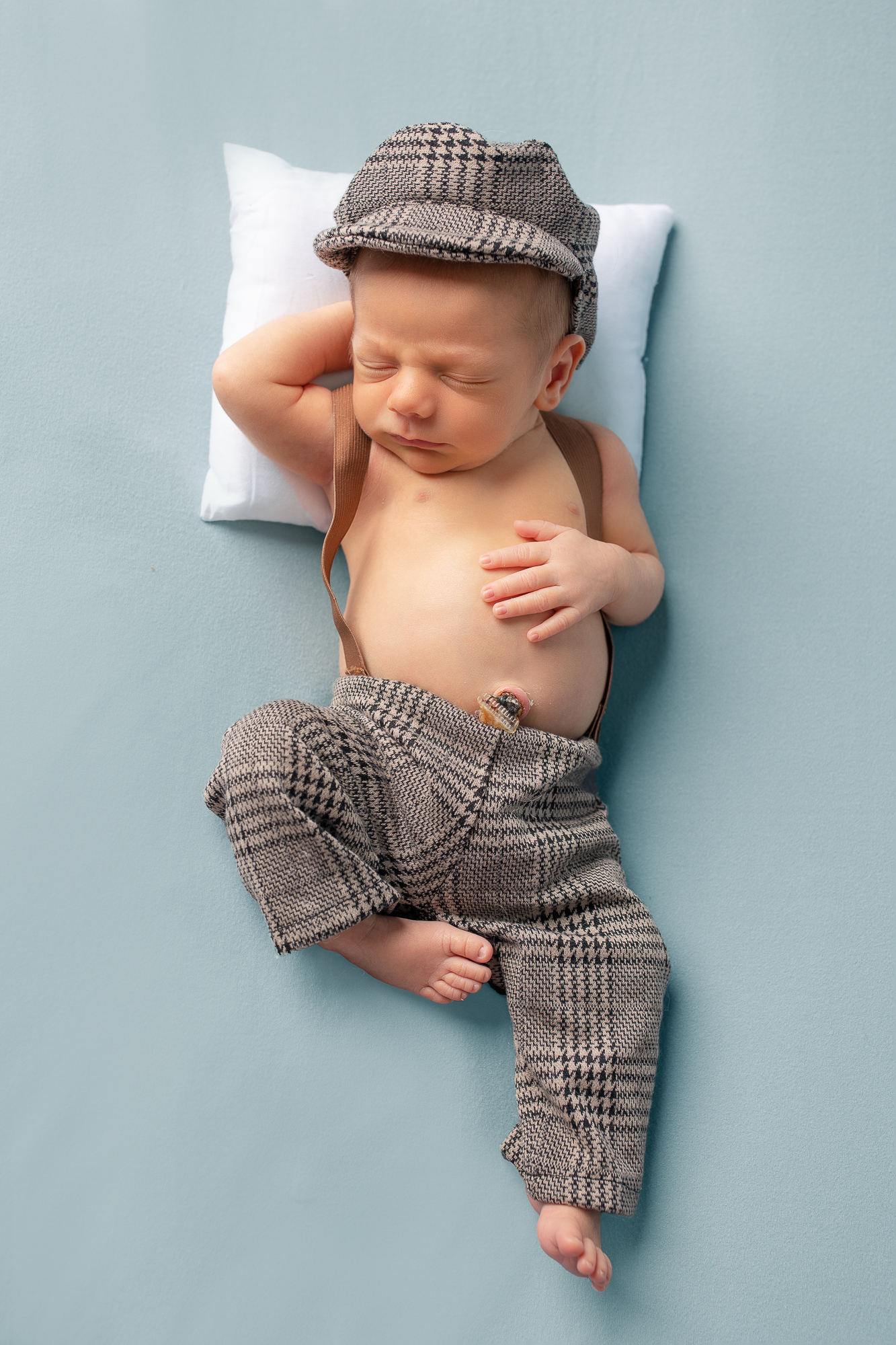newborn baby Boy posing  laying in gentleman outfit