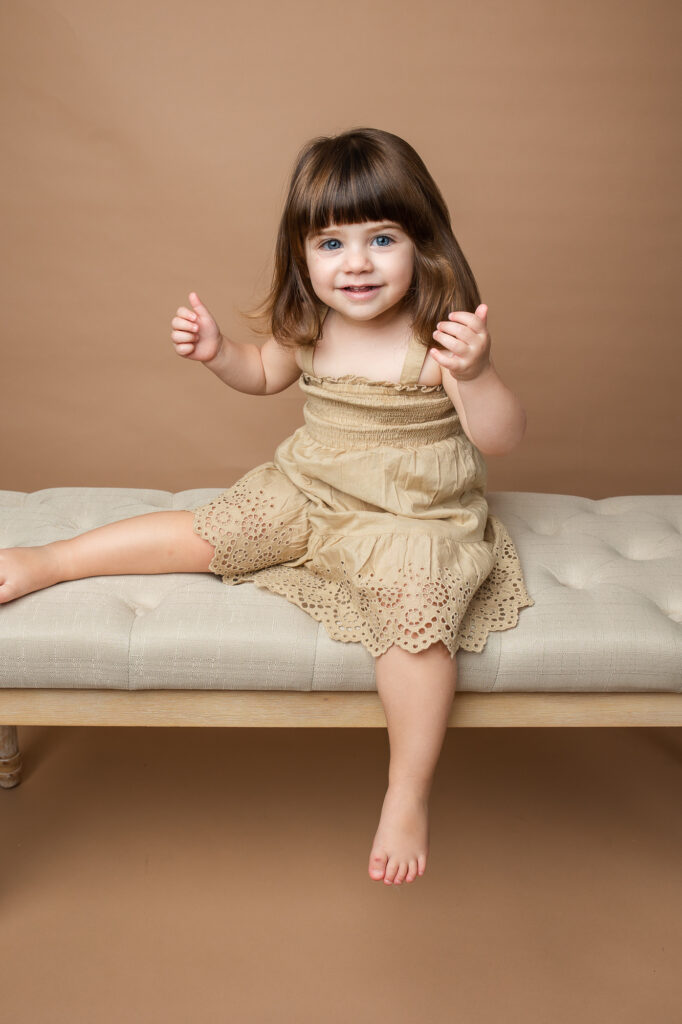 cute toddler girl with bangs, brown and beige, blue eyes dark hair