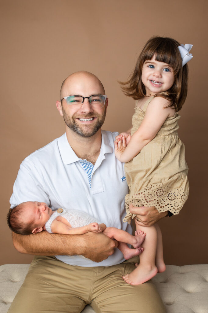 dad and two children - a newborn and a toddler, mocha brown savage paper background
